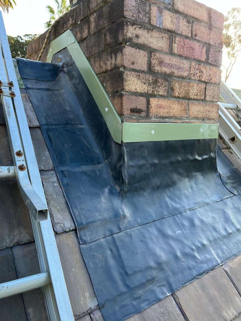 Box gutter and flashing worked in around a brick chimney