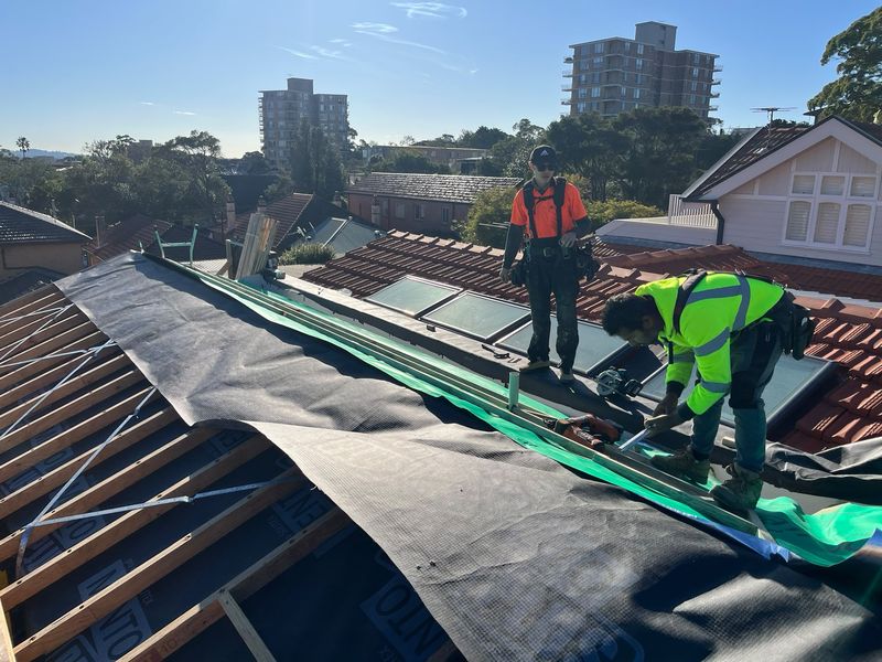 The crew laying sarking and battens for a new roof